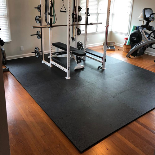 Home gym flooring with rubber mats and workout equipment in garage gym