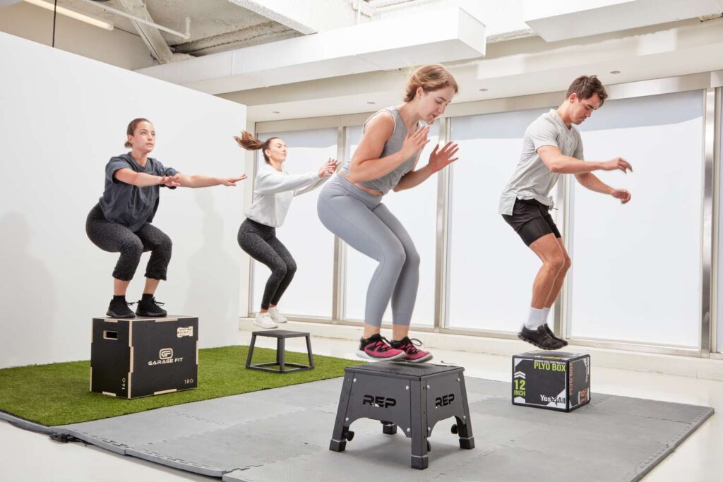 Athlete performing box jumps on a plyometric box in a home gym