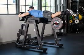 Athlete performing glute ham raise on a GHD machine in a home gym