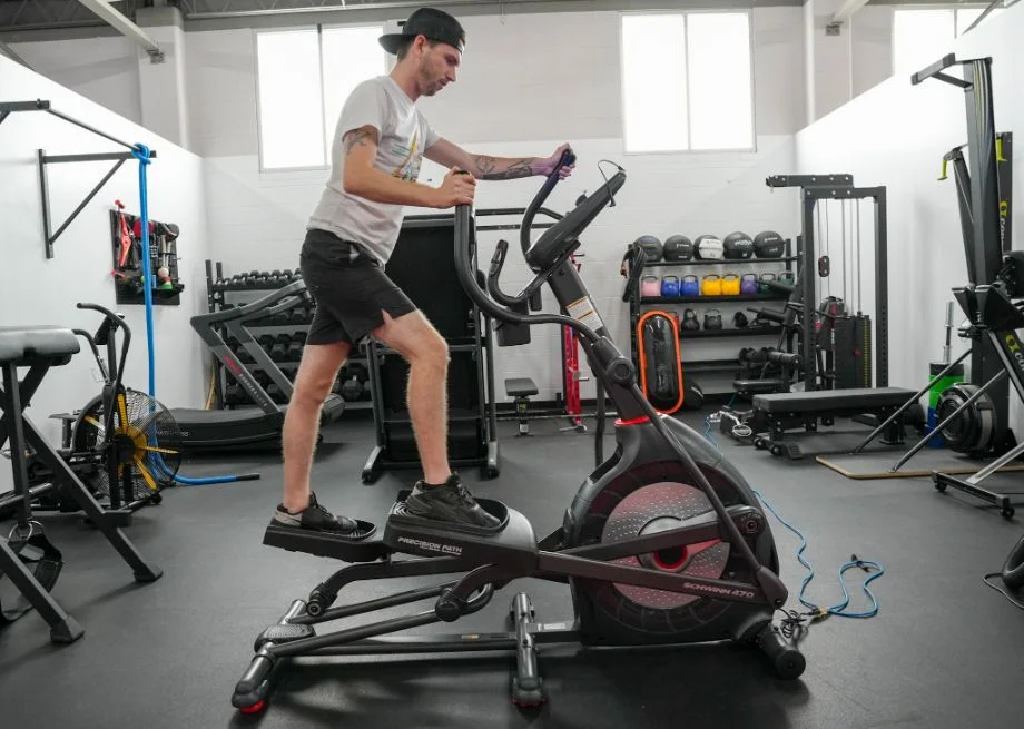 person using heavy-duty elliptical machine for home gym cardio workout