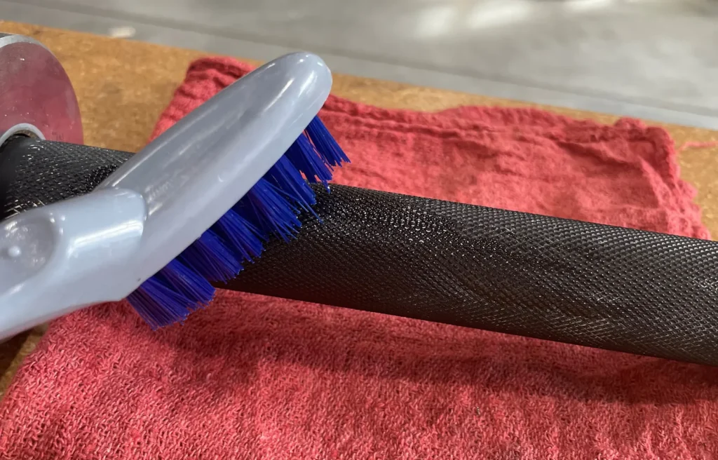 barbell cleaning brush and maintenance tools in home gym